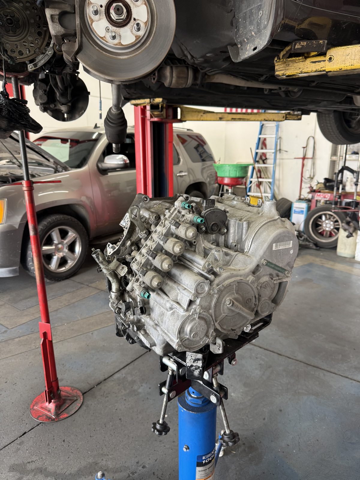 Engine pulled from a vehicle on a stand under the lift